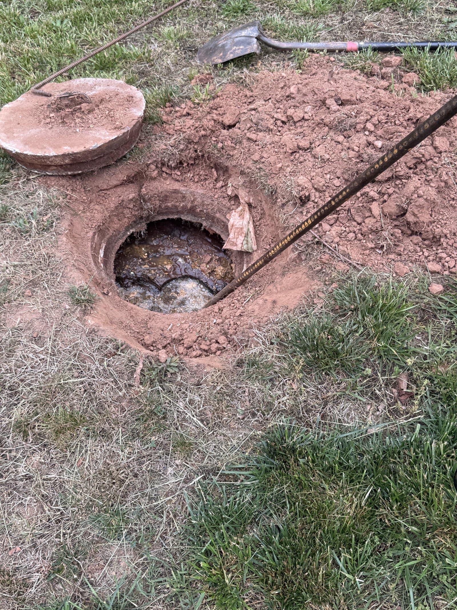 Close-up of the vacuum hose seated in the open septic tank during pumping