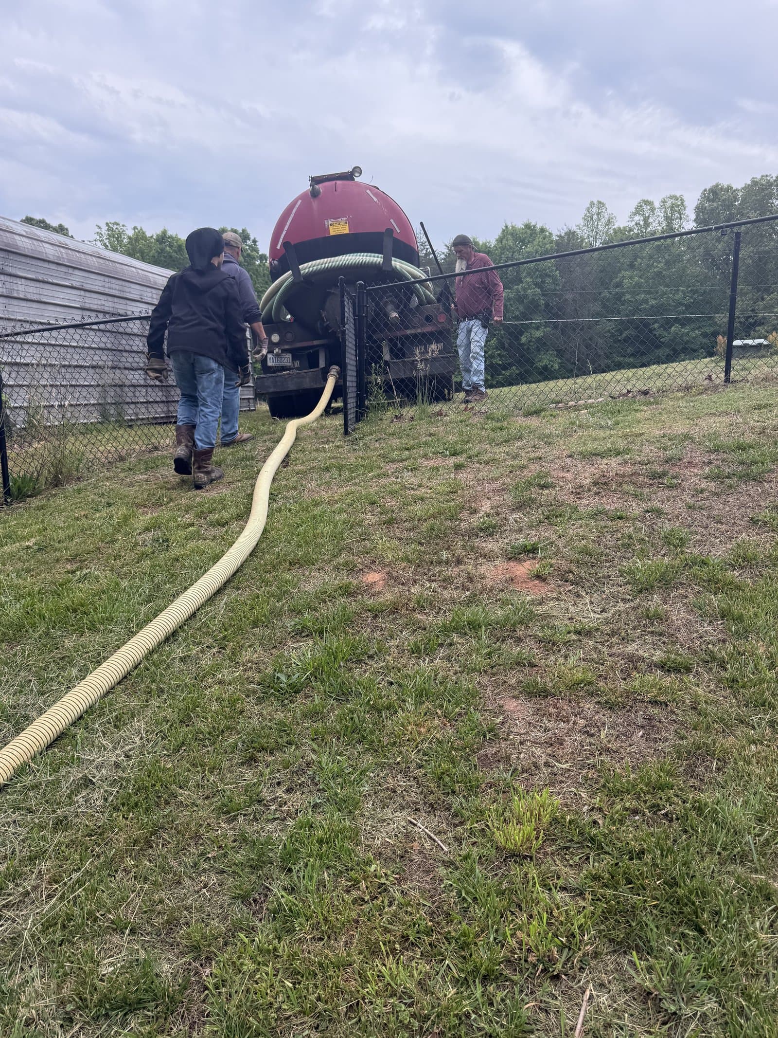 Palmer Septic vacuum truck deployed at a residential job site with hose extended